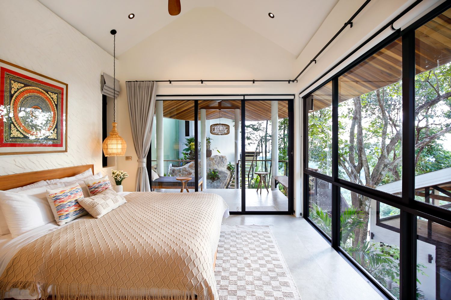 Bedroom with framed art, a ceiling fan and sliding doors onto its own covered terrace