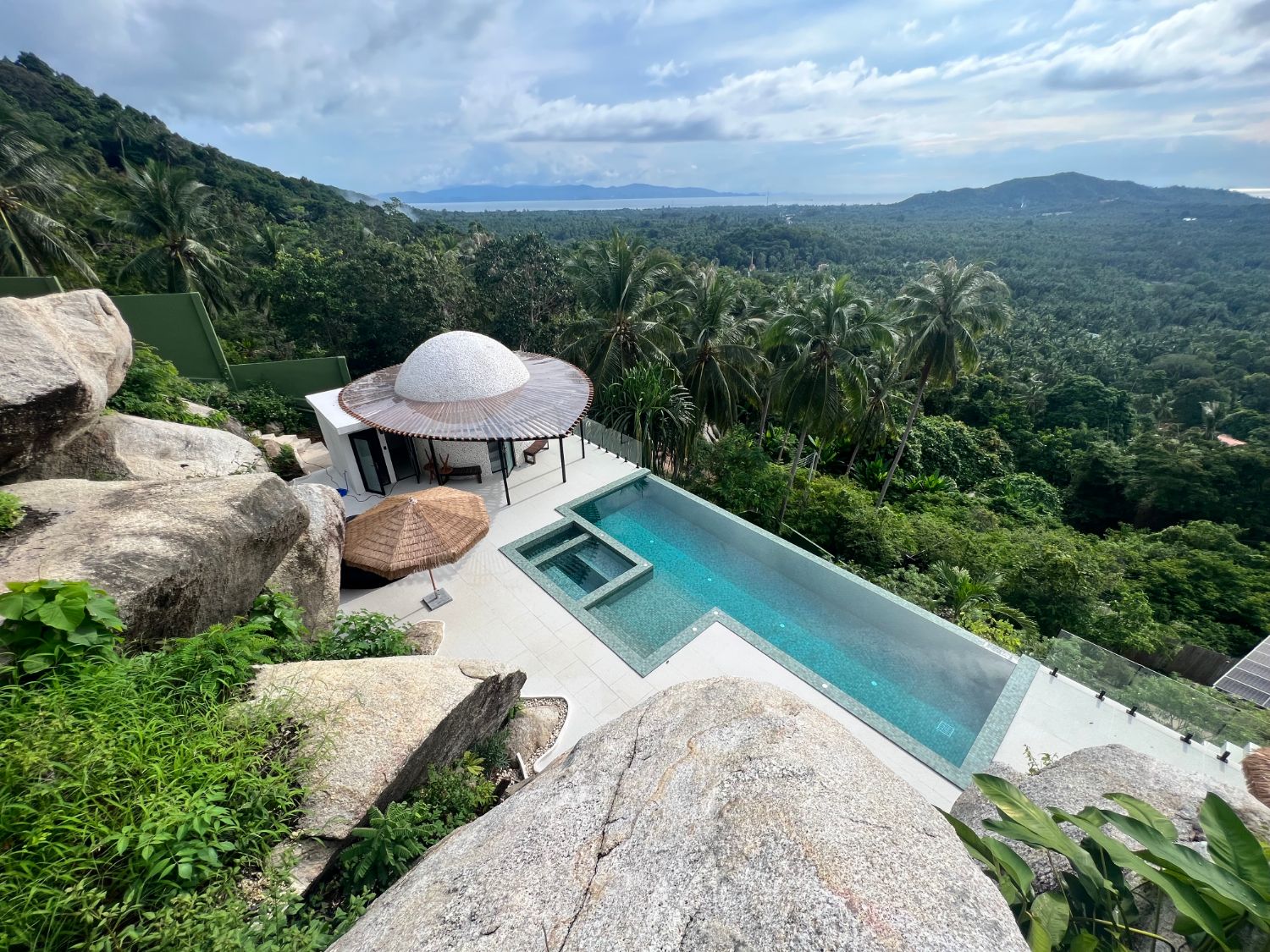 Looking down over the pool, the dome and the terrace to the jungle and the sea beyond